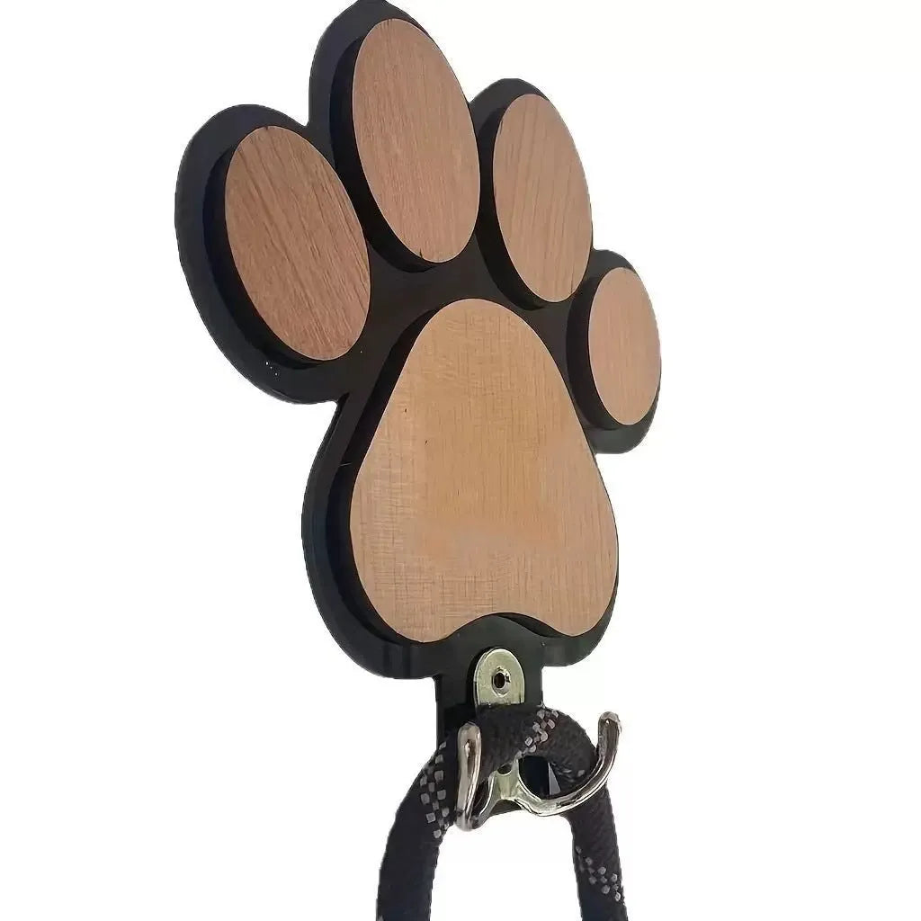 Black wooden wall hook shaped like a paw print foot on a white wall