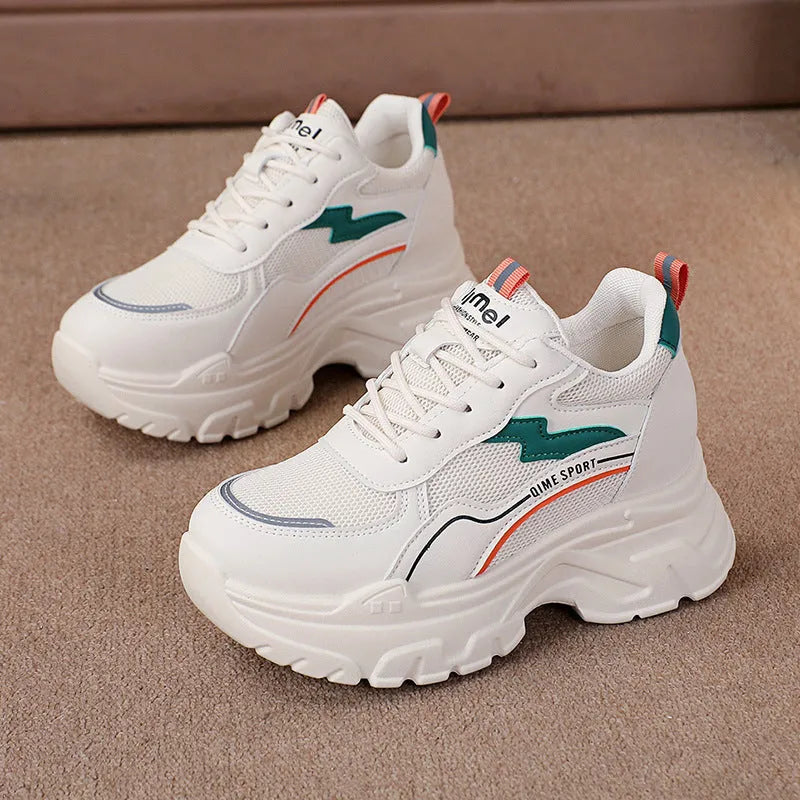 White women's dad sports trainers with cross straps and a lace-up front on a rubber sole.