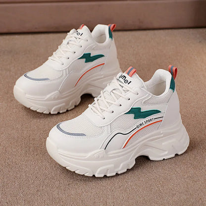 White women's dad sports trainers with cross straps and a lace-up front on a rubber sole.