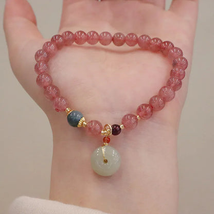 Natural strawberry quartz geometric bracelet with a small purse charm and silver safety buckle closure.