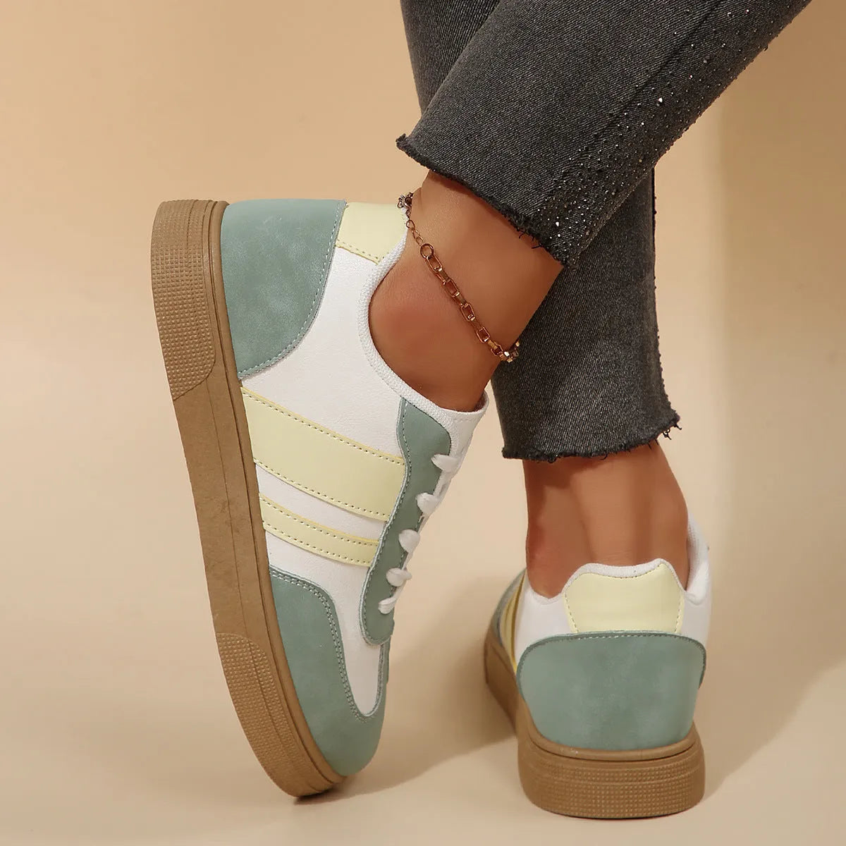 Women's green and white retro-style low-top casual pumps with cross straps and a flat rubber sole.