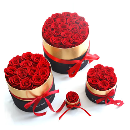 Luxury gift box containing an arrangement of preserved red eternal roses on a dark background.