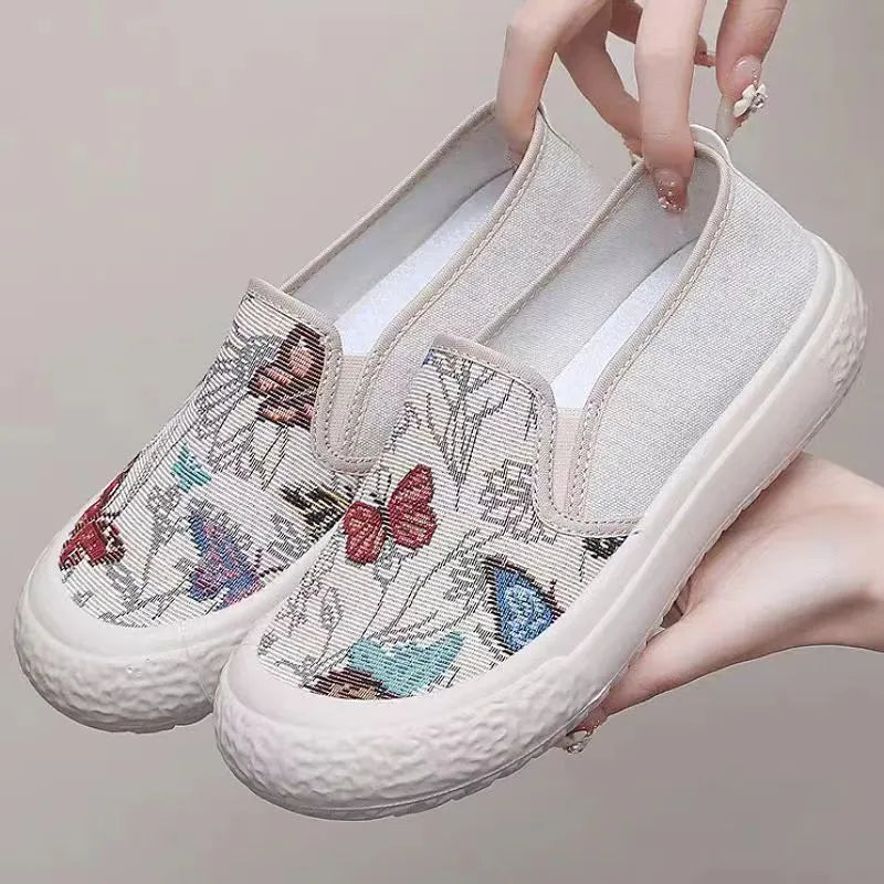 Women's black and white slip-on canvas shoes with round toe and decorative stitching