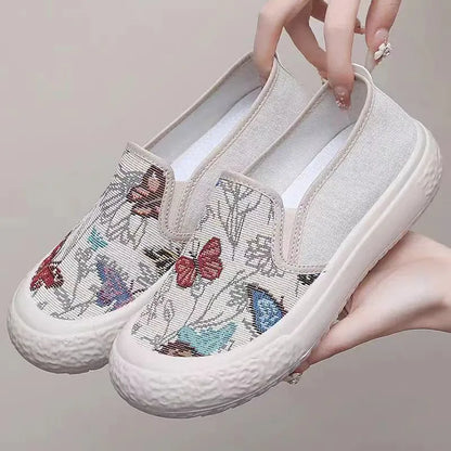 Women's black and white slip-on canvas shoes with round toe and decorative stitching