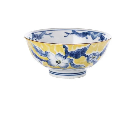 Yellow ceramic tableware set with colourful floral patterns, includes bowls and plates in Japanese style