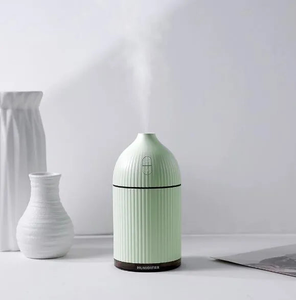 White ultrasonic aromatherapy diffuser and air humidifier with LED light, 300ml capacity, on a desk.