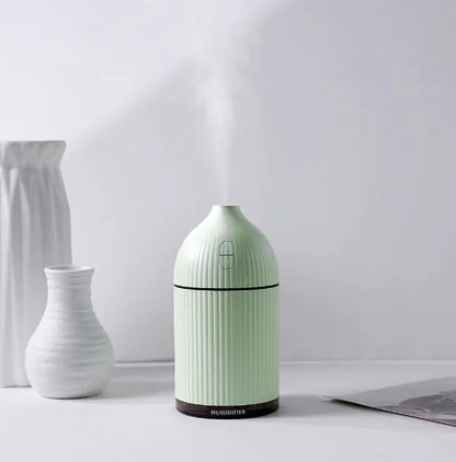 White ultrasonic aromatherapy diffuser and air humidifier with LED light, 300ml capacity, on a desk.