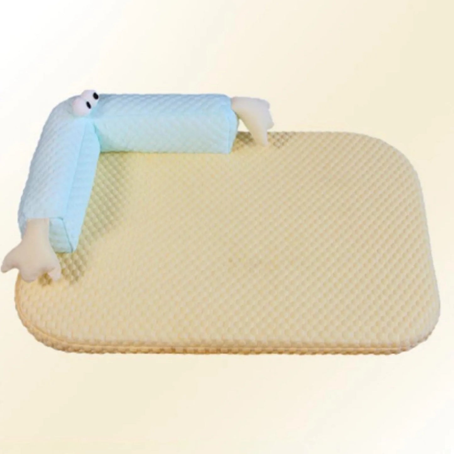 Blue pet bed cushion with big-eyed monster design, shown on a wooden floor.