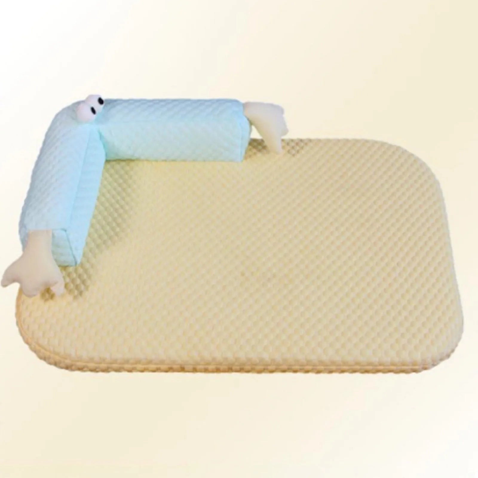 Blue pet bed cushion with big-eyed monster design, shown on a wooden floor.