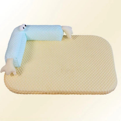 Blue pet bed cushion with big-eyed monster design, shown on a wooden floor.