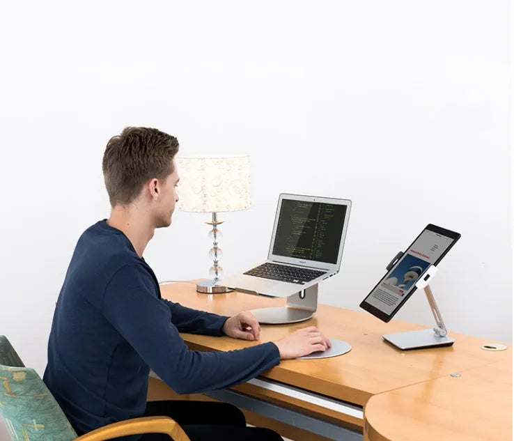 Silver folding phone and tablet stand holding a device, showing its 360-degree rotation and compact size