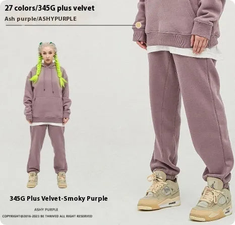 Man wearing solid colour cotton velvet sweatpants with an ankle banded design in a dark grey shade.