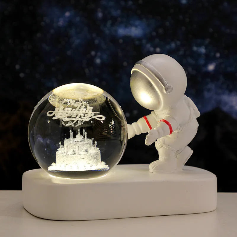 Glowing astronaut crystal ball night light with 6cm diameter and USB cable on wooden surface