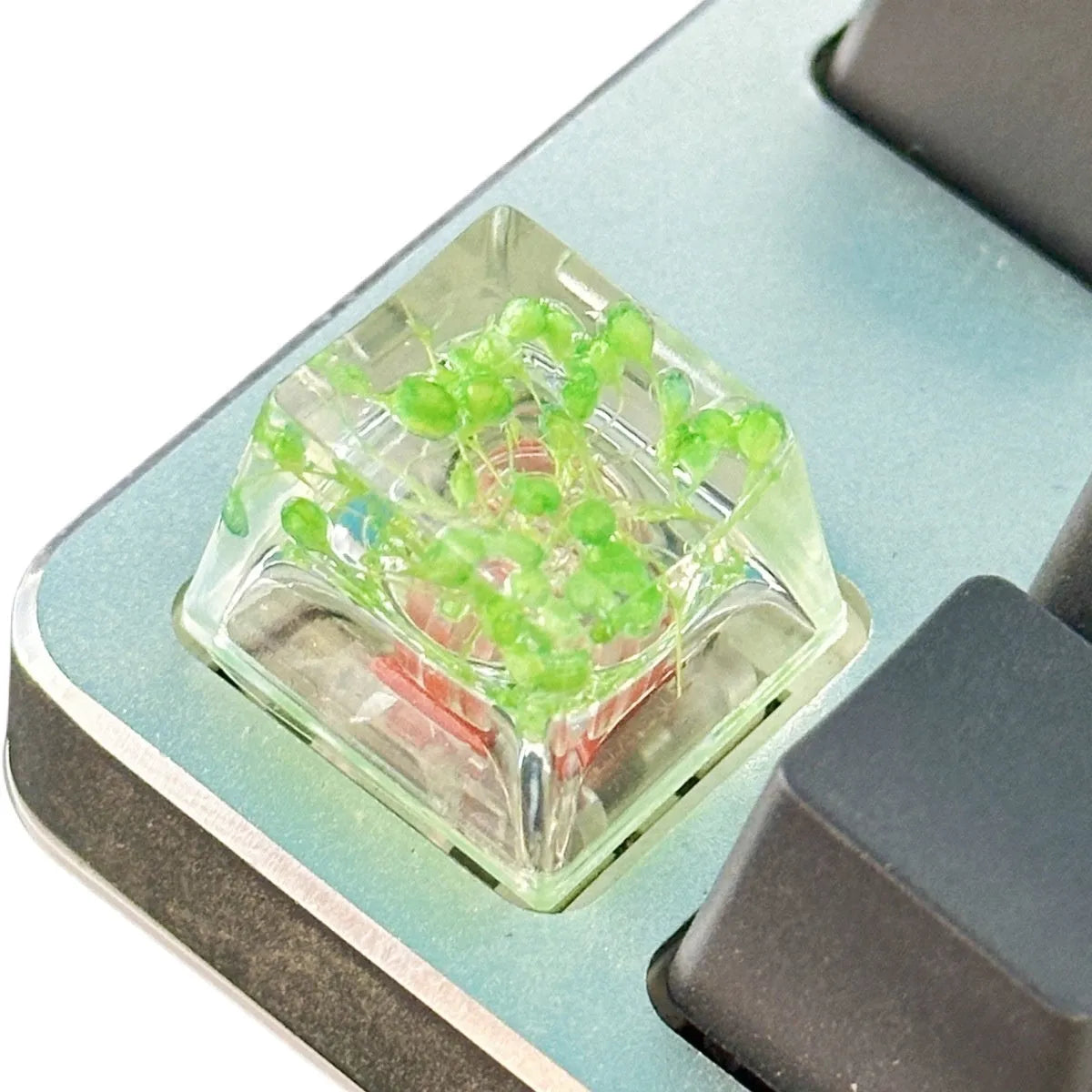Transparent resin mechanical keyboard keycap with glitter starry sky effect in red, pink, green, or violet.