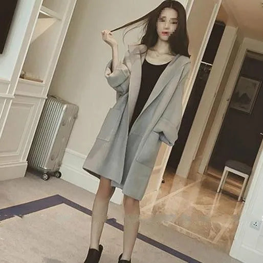 Plus size woman modelling a loose fit grey thin coat with lace detailing and long sleeves.