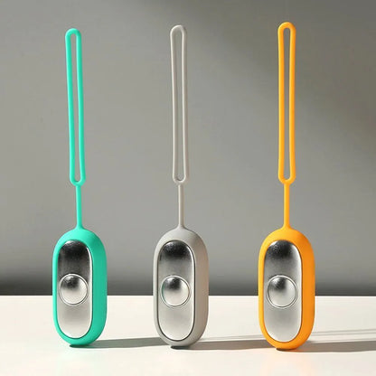 Hand-held micro-current sleep aid device in grey, green, or orange with round button and USB charging port