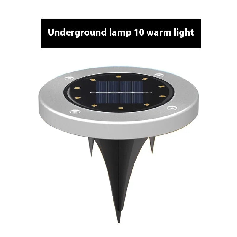 Stainless steel solar garden ground lamp installed in a lawn.