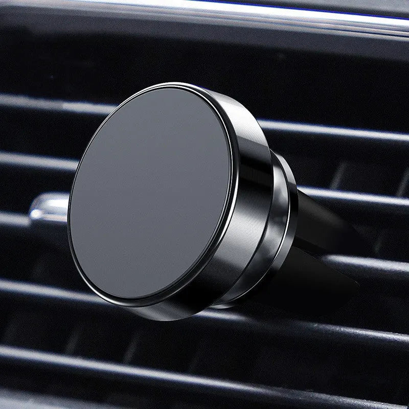 Silver aluminium alloy magnetic car phone holder with rotating ball head mounted on a car air vent.