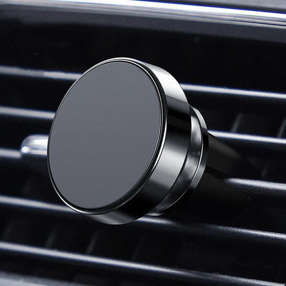 Silver aluminium alloy magnetic car phone holder with rotating ball head mounted on a car air vent.