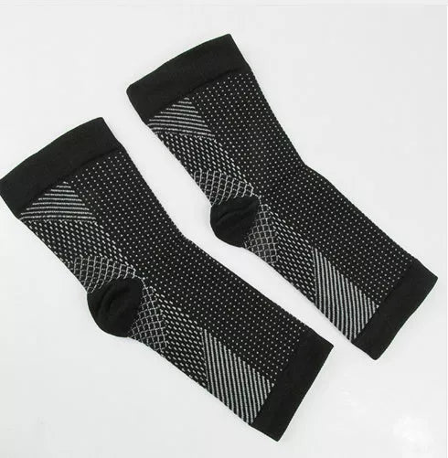 Anti-fatigue compression foot sleeve in black, red, or white, featuring moisture-wicking fabric and a heel hole for breathability.