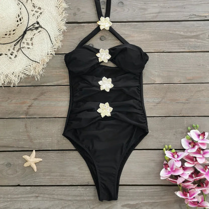 Women's solid colour one-piece swimsuit with attached short skirt in black, showing high-waisted fit and hollow-out tube top design.