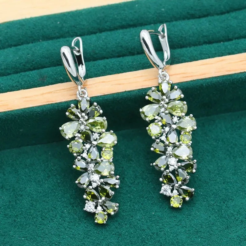 Vintage jewellery set with floral patterns showing necklace, bracelet, earrings and ring in olive green colour