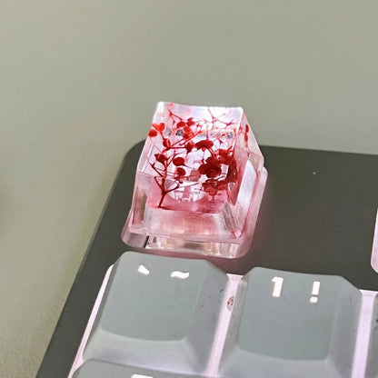 Transparent resin mechanical keyboard keycap with glitter starry sky effect in red, pink, green, or violet.