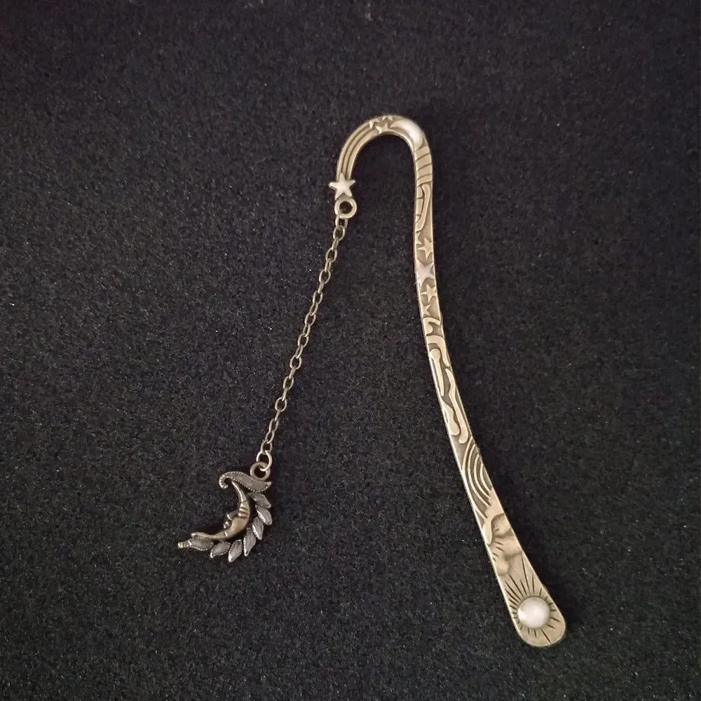 Retro five-pointed star glowing metal bookmark in ancient silver and bronze finishes on an open book.