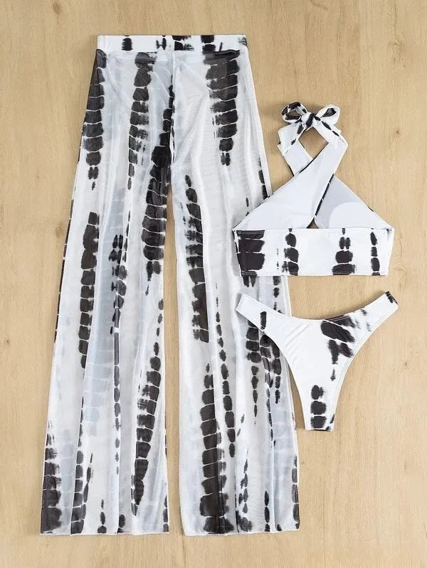 Women's black printed three-piece swimsuit set with mesh trousers laid flat.