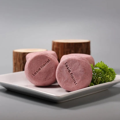 Pink round handmade rosewood grinding soap with roselle and tangerine peel ingredients