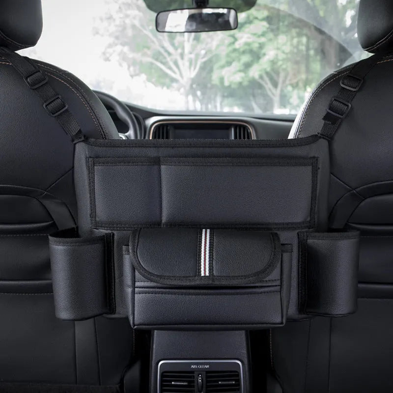 Black leather car seat gap storage bag hanging from armrest with tissue box, showing textured grain detail.