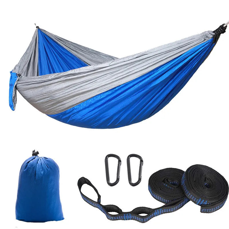 Parachute cloth double camping hammock in chosen colour, with black buckles and round ropes on a tree.