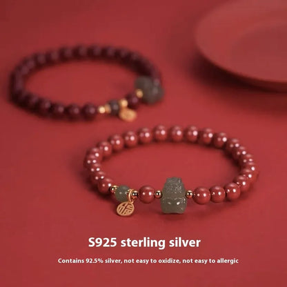 Natural Hetian jade bracelet with zodiac carvings and cinnabar accents in 8mm diameter