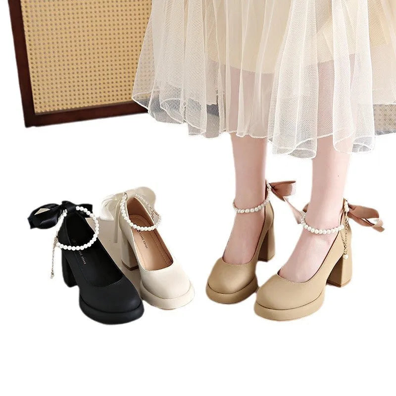 Women's beige preppy style Mary Jane shoes with chunky heel, ankle strap buckle, and pearl detail.