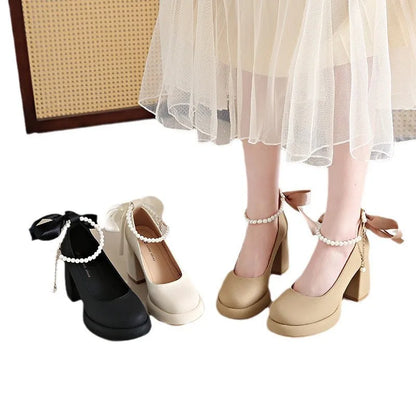 Women's beige preppy style Mary Jane shoes with chunky heel, ankle strap buckle, and pearl detail.