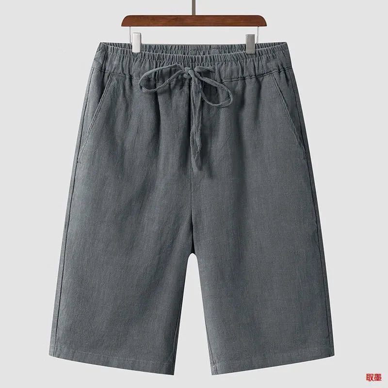 Men's beige linen casual shorts with a loose fit and elastic waistband on a neutral background.