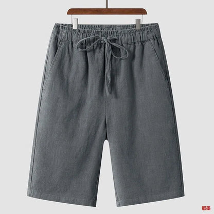 Men's beige linen casual shorts with a loose fit and elastic waistband on a neutral background.