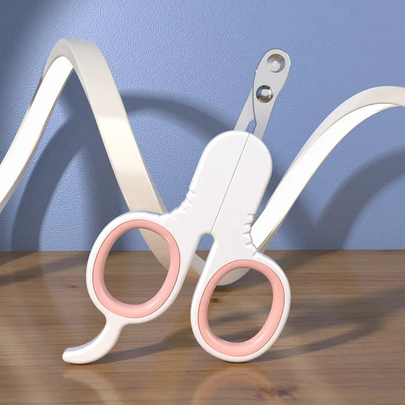 Grey and pink pet nail clippers with curved tips and a rubber-coated ergonomic handle on a table.