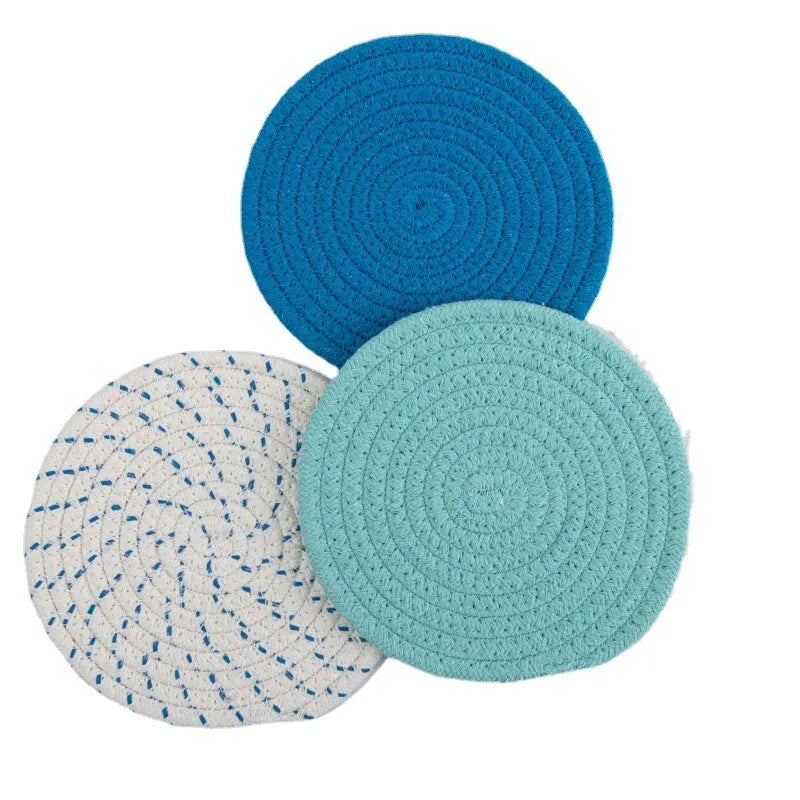 Three round grey cotton cord coaster placemats on a wooden table, each 18cm in diameter.