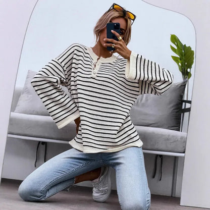 Black and white striped women's casual top with drop-shoulder sleeves and button detail