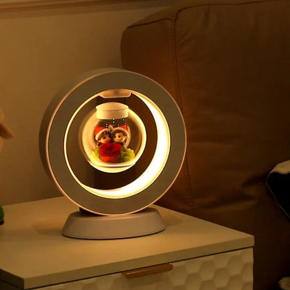 Pink rose eternal flower floating in magnetic levitation LED night light with triangular base and touch control