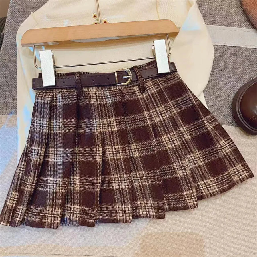 Girls' plaid pleated A-line skirt in cotton blend fabric, shown on a hanger.