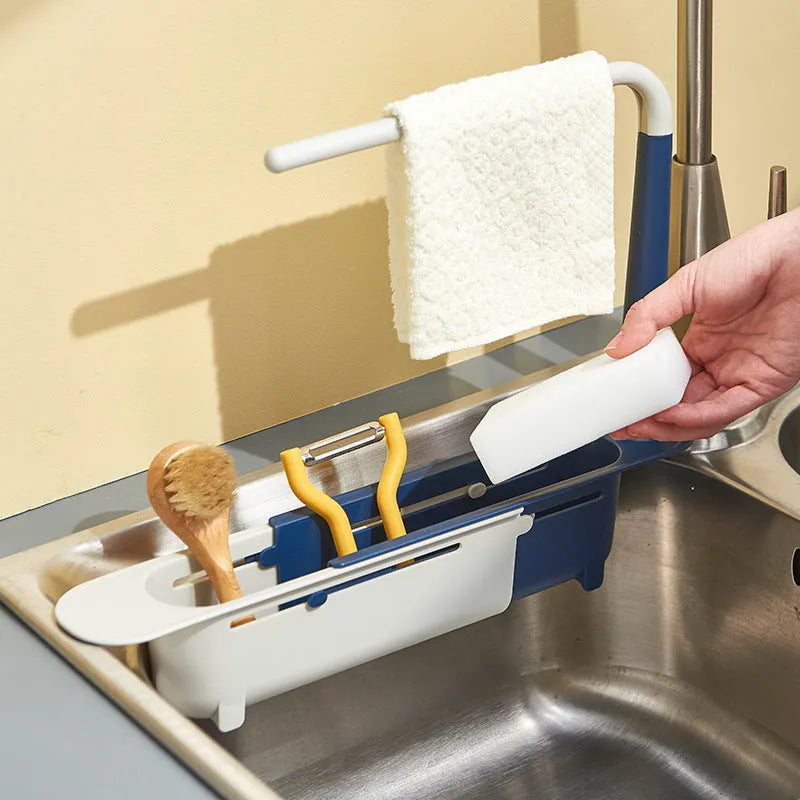 Telescopic plastic kitchen sink drain rack with multi-coloured modular baskets.
