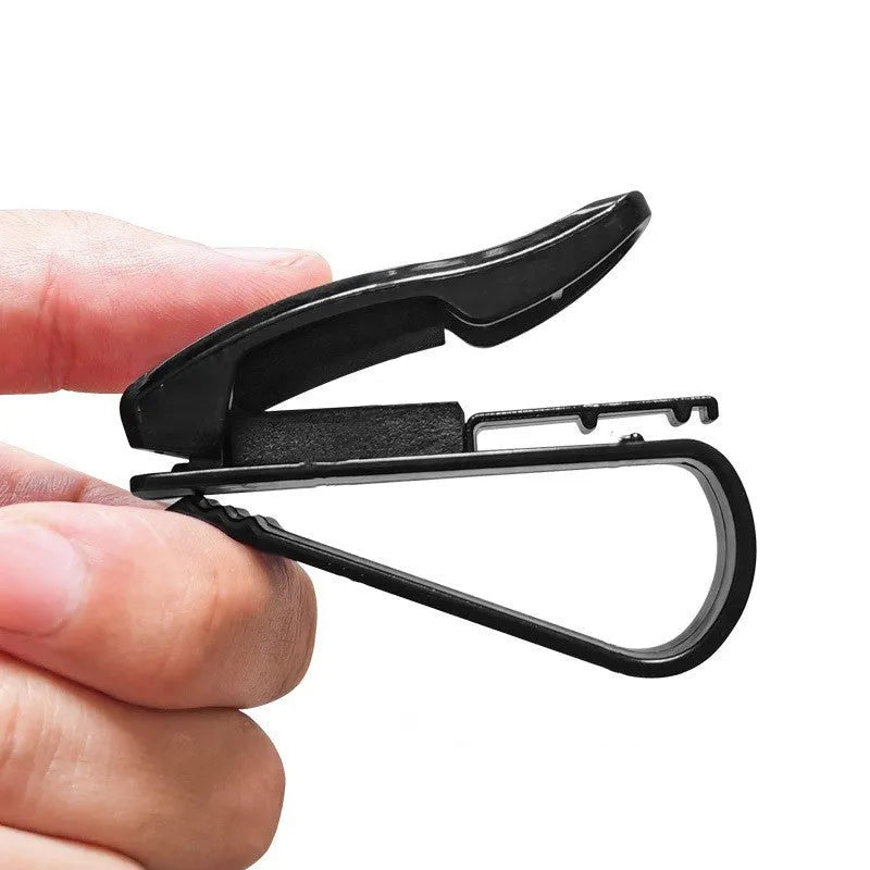 Black plastic clip for car sunshades to hold tickets, ID cards, or glasses.