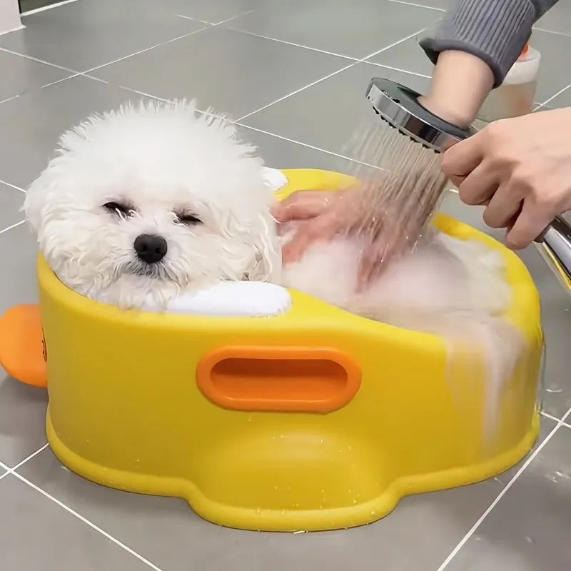 Blue PVC duck-shaped bathtub for washing a small dog, shown on a tiled floor.