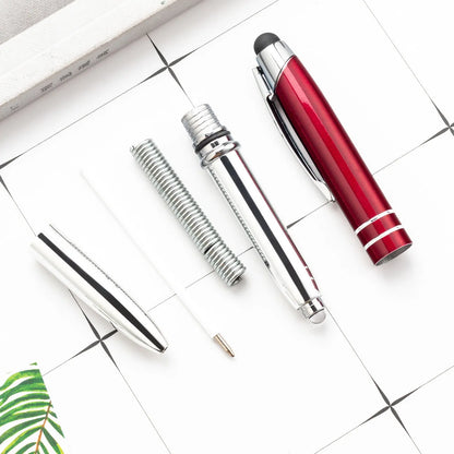 Red metal multifunctional stylus ballpoint pen with LED light on a desk.