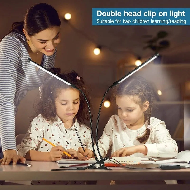 Black adjustable gooseneck desk lamp with USB cable bent over a notebook on a wooden desk.