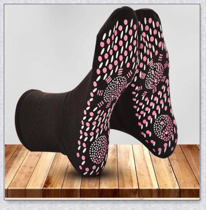 Pair of self-heating massage socks with detailed view of the acupressure-inspired soles