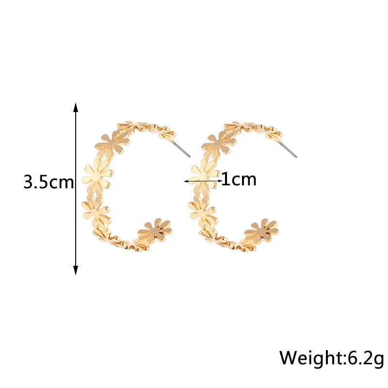 Pair of golden geometric C-shaped flower drop earrings with a vintage-inspired design