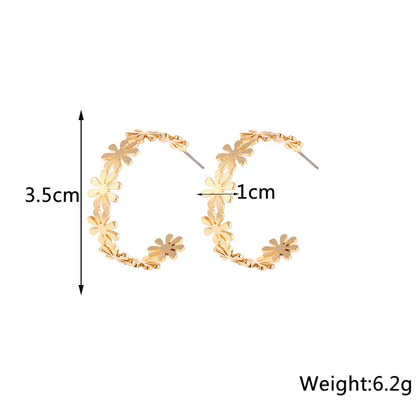 Pair of golden geometric C-shaped flower drop earrings with a vintage-inspired design